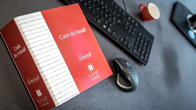 Foto de martelo da justiça junto a carteiras de trabalhos e livros de direito